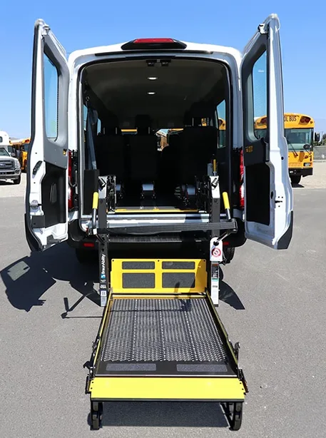 back of a full sized van in white with the back doors open displaying a wheelchair lift